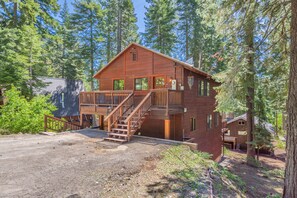 A two-story log cabin with a wooden deck and stairs leading to a balcony. - Tahoe Park Lodge 4 Bedroom Home (Tahoe City)
