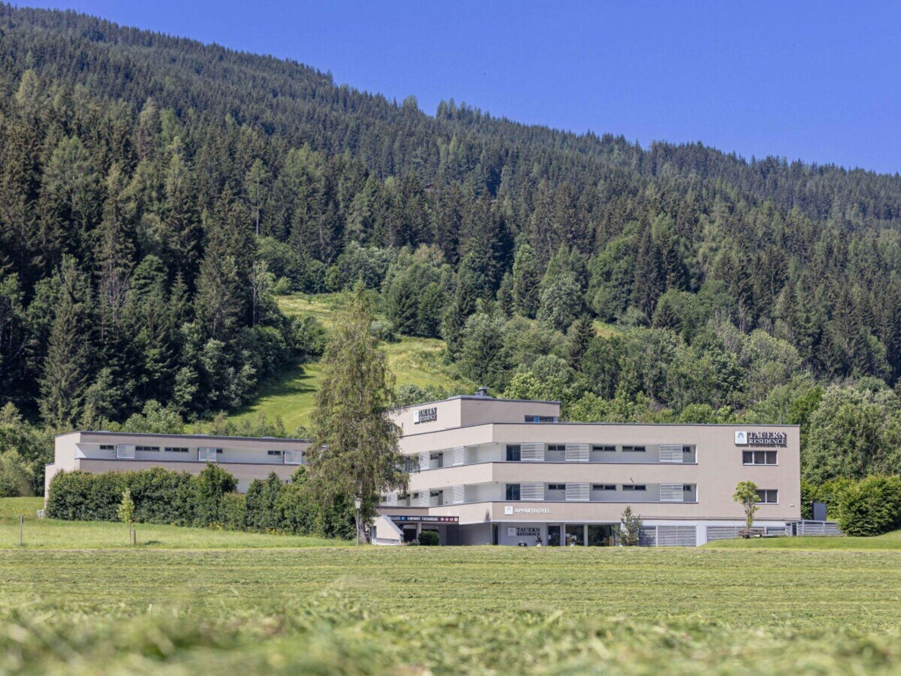 Un hotel moderno con techo plano, múltiples ventanas y un letrero que indica que es un 'HABITAT RESIDENCE'.
