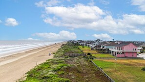 A coastal residential area with beachfront properties, a sandy beach, and a clear sky. - Sweet Escape: 2  BR, 2.5  BA House in Crystal Beach, Sleeps 7 (Crystal Beach)