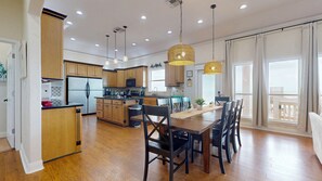A spacious kitchen with wooden cabinets, a central island, and pendant lighting. - Sweet Escape: 2  BR, 2.5  BA House in Crystal Beach, Sleeps 7 (Crystal Beach)