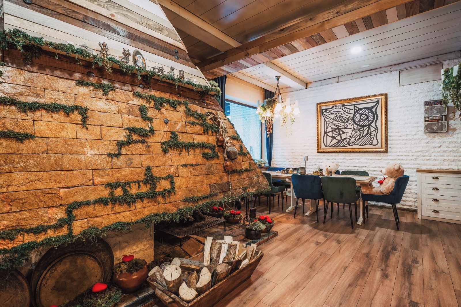 A rustic interior with a brick fireplace, wooden beams, and a dining area with chairs and a table.