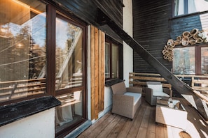 A wooden deck with wicker furniture and a staircase.
