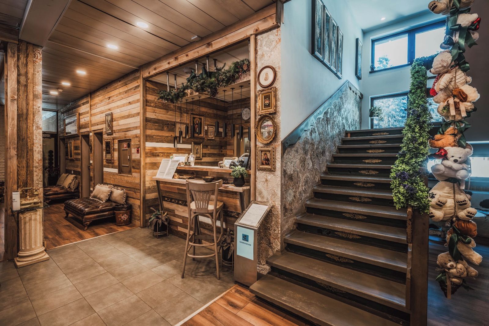 Un interior de madera con una escalera, una zona de bar y un área de estar con mobiliario de cuero.