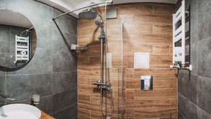 Uma casa de banho moderna com chuveiro, lavatório e sanita.