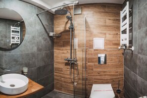 Un baño moderno con ducha, lavamanos e inodoro.