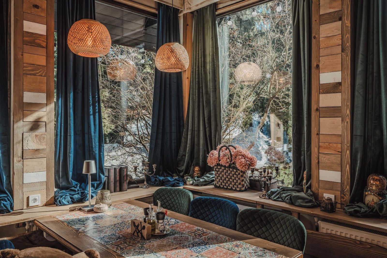 Una habitación acogedora con un ventanal grande, una pared de madera, una mesa de comedor y una zona de estar confortable.