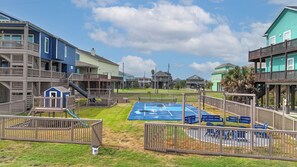 A playground with a basketball court and slides, surrounded by houses with balconies. - Seaside Paradise: 5  BR, 3  BA House in Crystal Beach, Sleeps 16 (Crystal Beach)