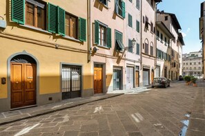 A street with buildings, a car parked on the side, and a clear sky. - Attic Piazza Santa Croce with living terrace (FIRENZE)
