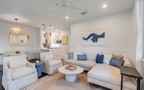 A modern living room with a sofa set, a coffee table, and a dining area with chairs. - Southern Yankee | Cozy Rosemary Beach Condo (Rosemary Beach)