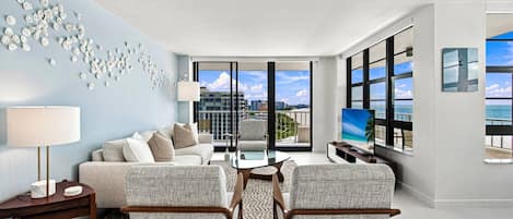 Una sala de estar moderna con un sofá, sillones, una mesa de centro y un televisor.