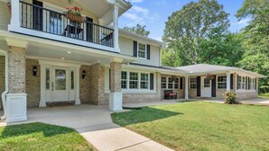 A two-story house with a covered porch, a brick facade, and a well-maintained lawn. - The Harness Creek Retreat in Annapolis (Annapolis)