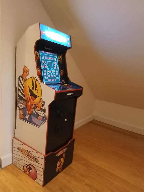 A retro arcade machine with a cartoon character on the side, a control panel, and a coin slot at the bottom.
