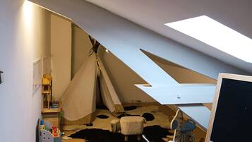A child's playroom with a tent, a rocking horse, and a red bicycle.