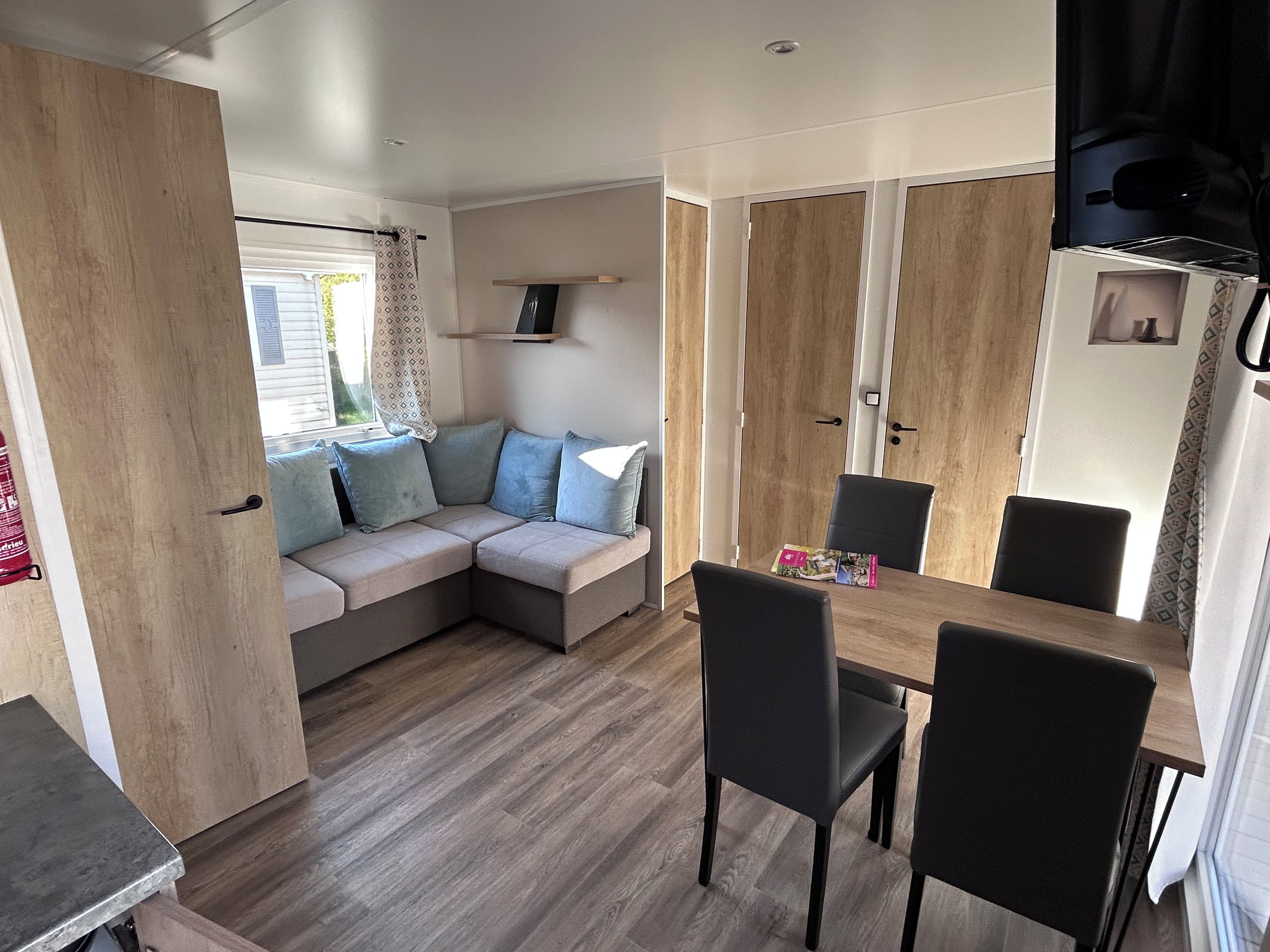 Un espacio habitable compacto con sofá, mesa de comedor, sillas y kitchenette.