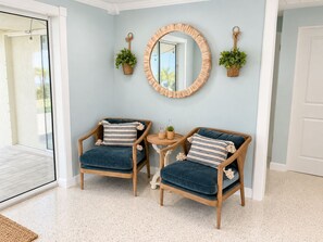 A room with two armchairs, a small round table, and a mirror on the wall. - 3/2.5 Canal Front Home, Private Pool, Dock on LBK (Longboat Key)
