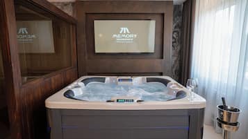 Une salle de bain moderne avec une baignoire à jets, un panneau de commande numérique et un panneau décoratif encadré placé au-dessus de la baignoire.