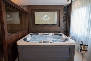 Un baño moderno con bañera spa, panel de control digital y un cartel enmarcado sobre la bañera.