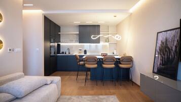Una cocina moderna con una isla central, taburetes de bar y una zona de comedor.