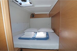 Habitación pequeña con literas, tragaluz y ventana.