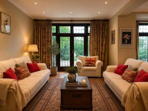 A living room with two sofas, a coffee table, and a large window with curtains. - Brook House (Stoke Poges)