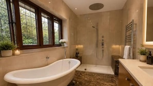 A bathroom with a freestanding bathtub, a walk-in shower, and a vanity with a mirror. - Brook House (Stoke Poges)