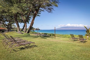A grassy area with metal lounge chairs and a view of the ocean. - Oceanfront Resort on N. Kaanapali Beach | Pools | Dining | Free Trolley (Lahaina)