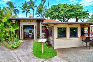 A cafe with a sign reading 'CASTAWAY CAFE,' outdoor seating, and a small garden area. - Oceanfront Resort on N. Kaanapali Beach | Pools | Dining | Free Trolley (Lahaina)