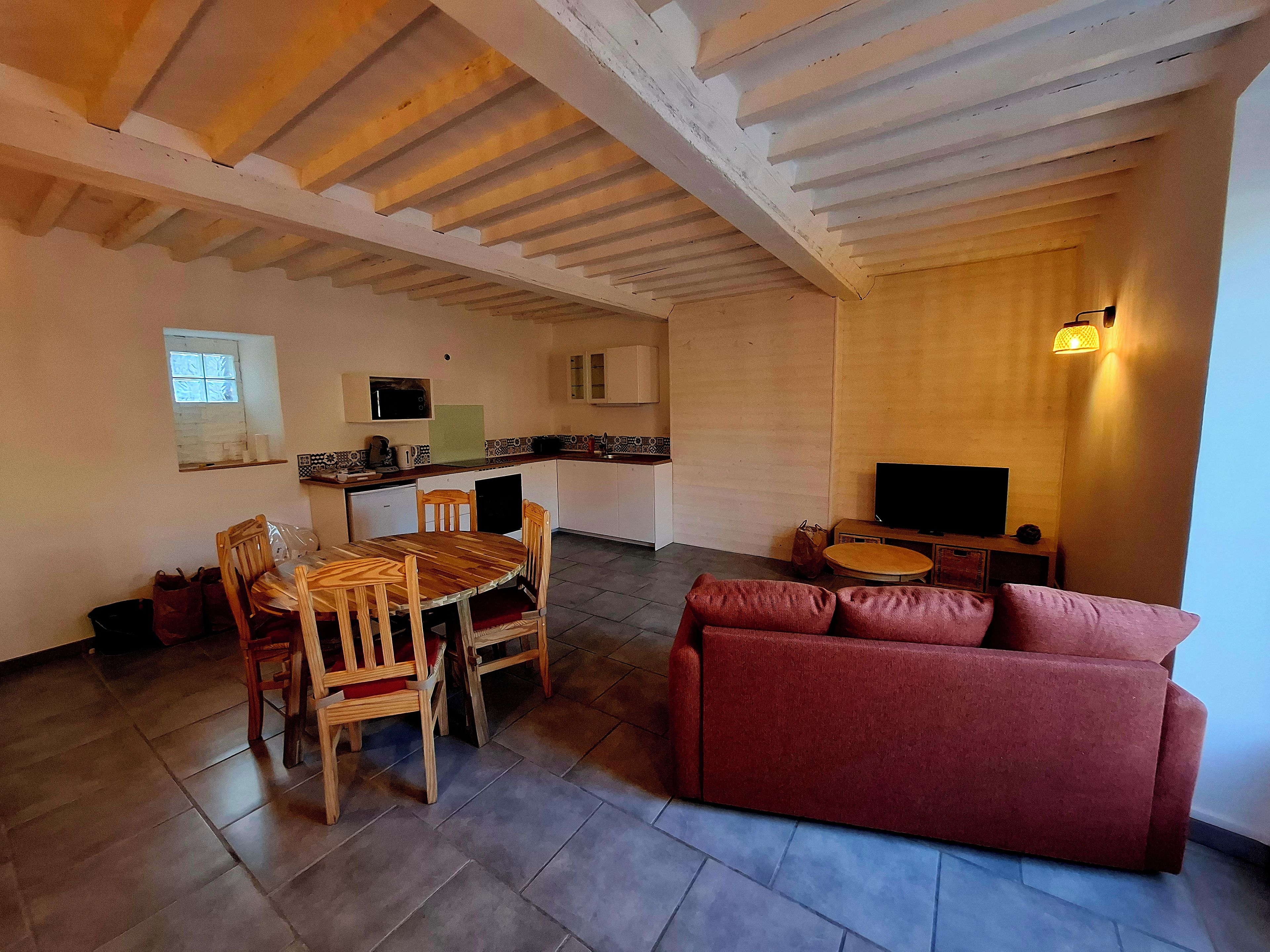 Un espace de vie compact comprenant un coin repas, une kitchenette et un coin salon.