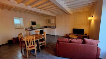 Een compact woongedeelte met een eethoek, kitchenette en zithoek.