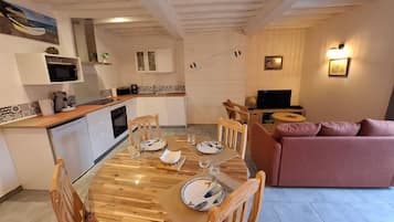 A compact living space with a dining area, kitchenette, and seating area.