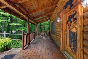 A covered porch with handcrafted bear carvings welcomes you to your forest retreat, with rocking chairs overlooking lush green woods perfect for morning coffee or evening relaxation. - Welcome to LeConte Lookout, your perfect Sevierville escape designed for family (Sevierville)