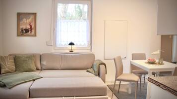 Ein gemütlicher Wohnbereich mit einer Couch, einem Esstisch und einem Stuhl.