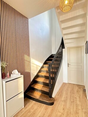 A staircase with wooden steps and black railings, leading to a white door. - Dinan • Renovated 2-bedroom house & exterior • Train station and downtown within walking distance (Dinan)