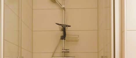 A shower with a handheld showerhead, a wall-mounted faucet, and a handheld showerhead.