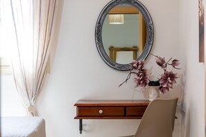 A room with a wooden dresser, a mirror, and a vase with flowers. - Villa Konstantinos in Heraklion (Heraklion)