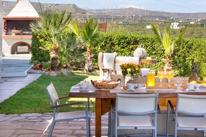 An outdoor dining area with a view of a mountainous landscape. - Villa Konstantinos in Heraklion (Heraklion)