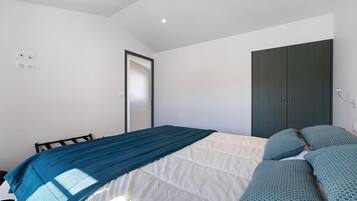 Ein Schlafzimmer mit Bett, Kleiderschrank und einer Tür.