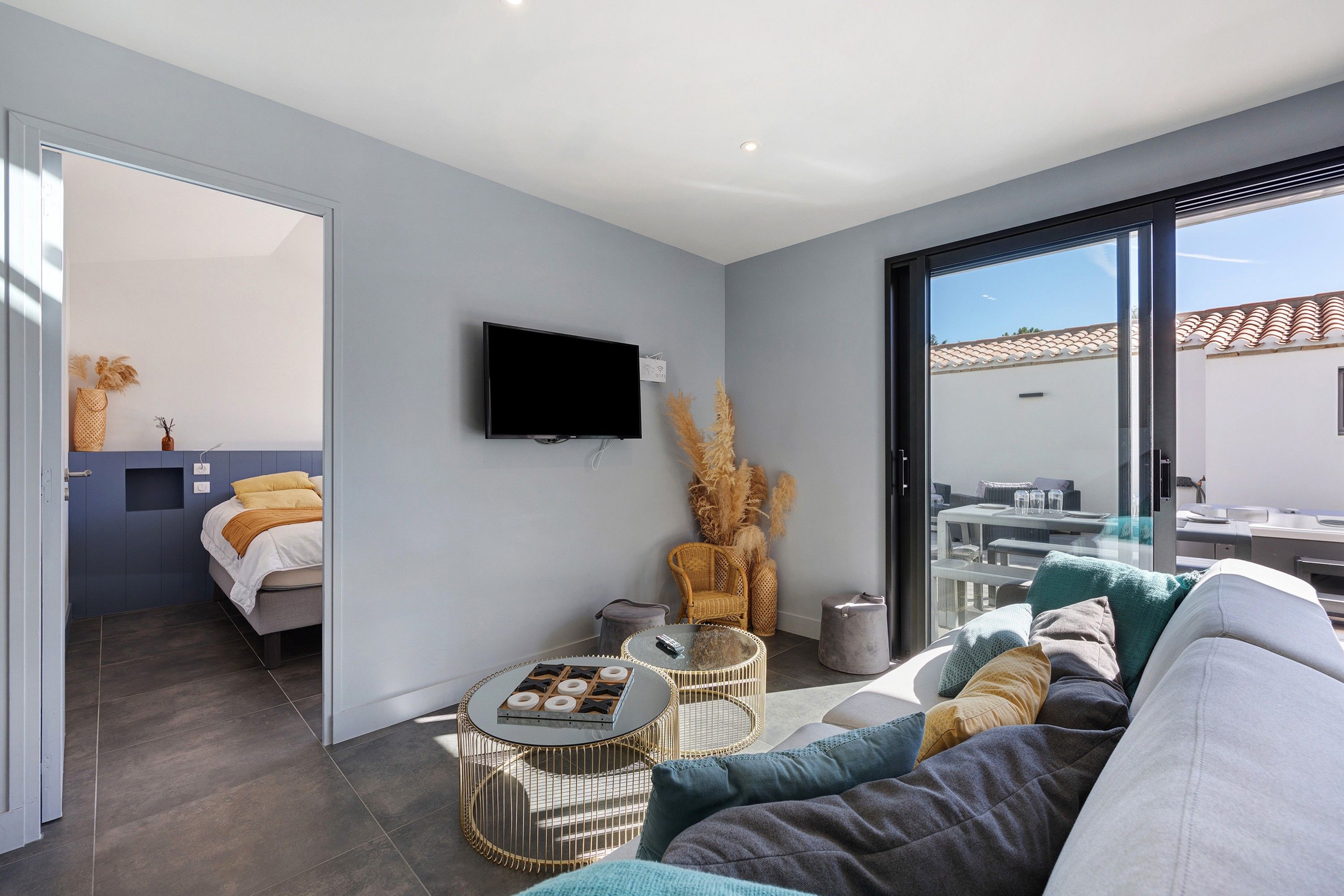 A modern living room with a sofa, a coffee table, and a flat-screen TV mounted on the wall.