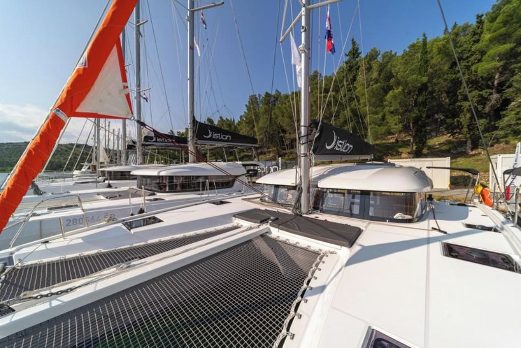 A marina with multiple sailboats docked, featuring a covered deck area and a helipad.
