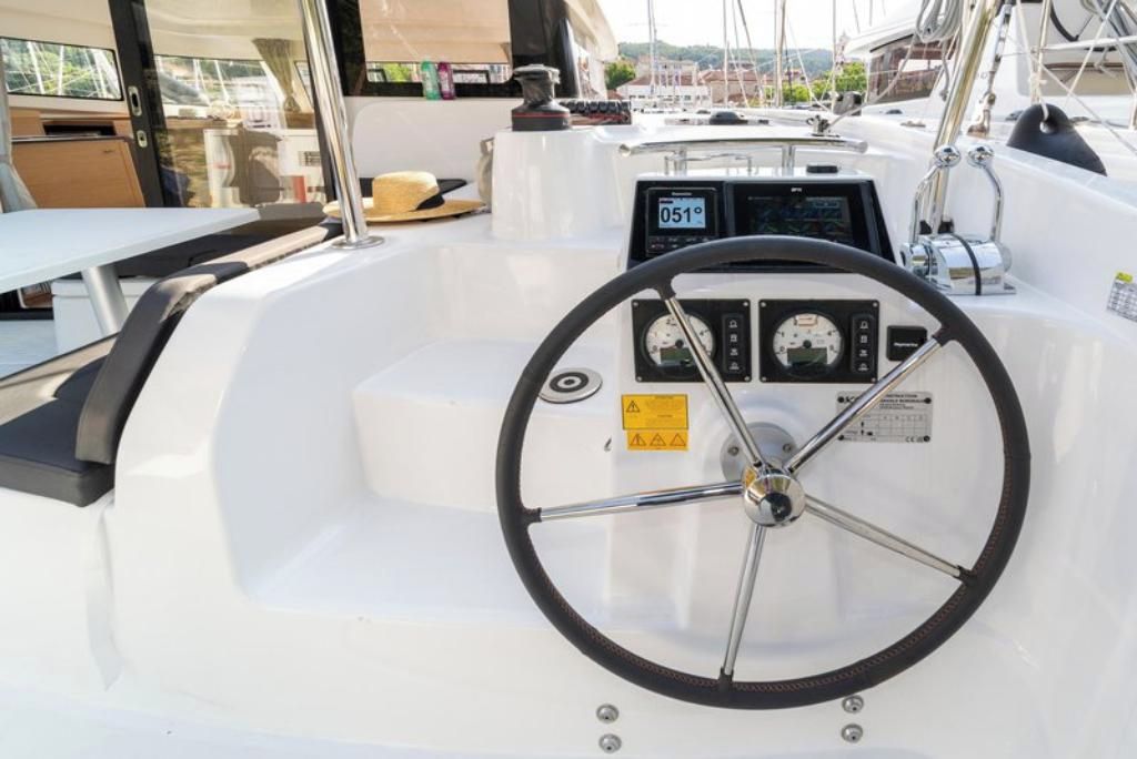 Le poste de pilotage d’un bateau, comprenant un volant, un panneau de commande et un espace pour s’asseoir.