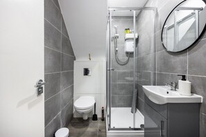 A modern bathroom with a toilet, shower, and sink. - Earl`s Court Residence | Elegant Studio | London (Greater London)