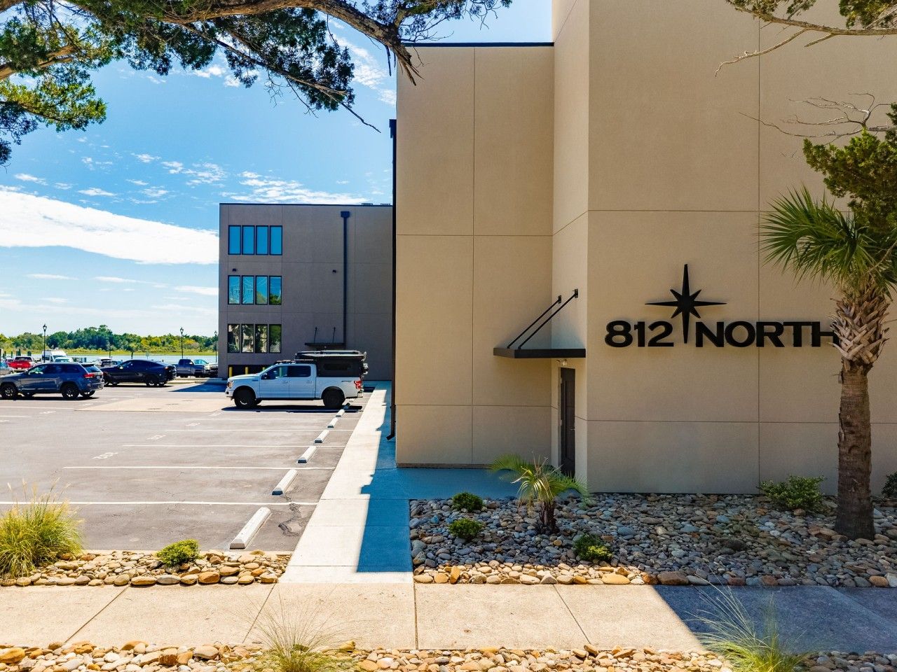 A building with a sign reading '812 NORTH' and a parking lot with several cars.