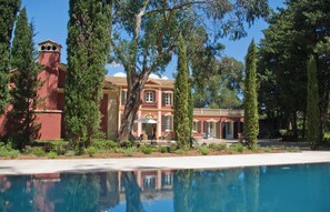 A large building with a swimming pool in front, surrounded by tall trees and greenery. - Villa Médicis – Sleeps 10, Private Pool, A/C & Walking Distance to the Sea (Le Pradet)