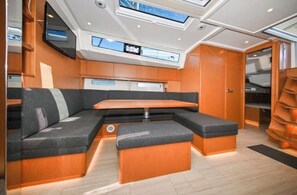 A modern interior with a seating area, a table, and a television mounted on the wall.