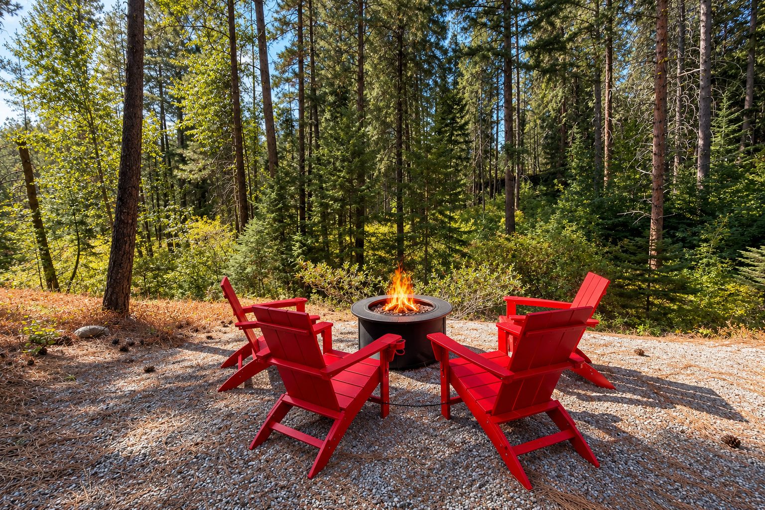 A forest setting with a fire pit and two red chairs.