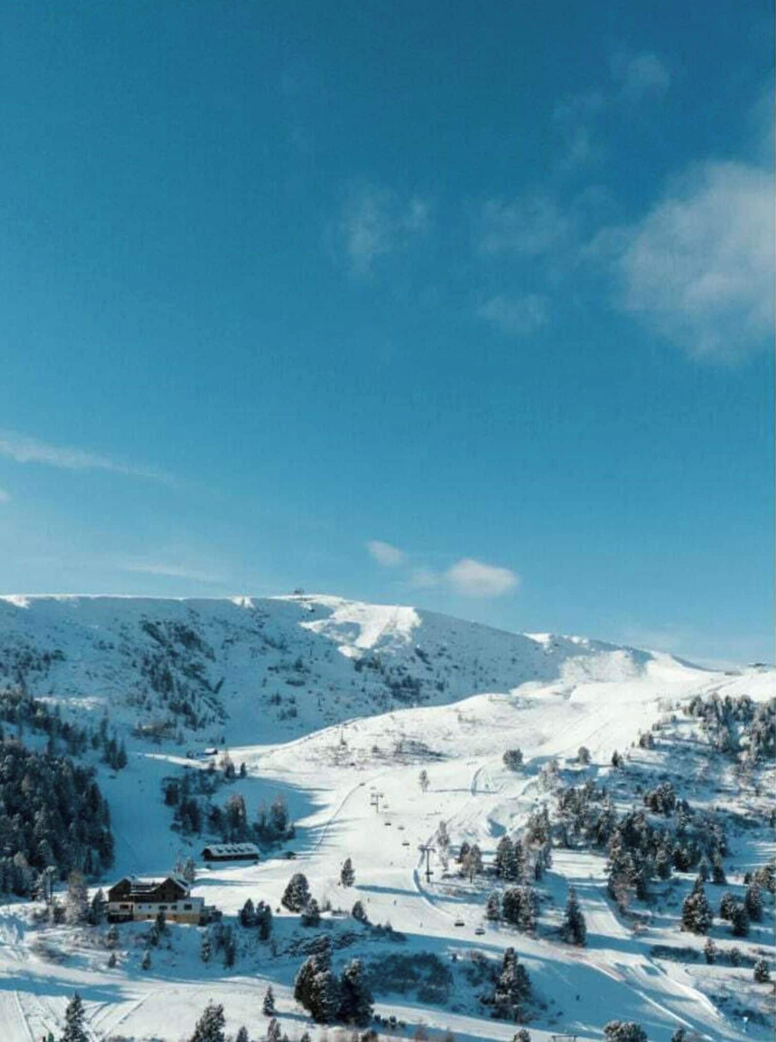 Ett snötäckt berglandskap med en klar himmel.