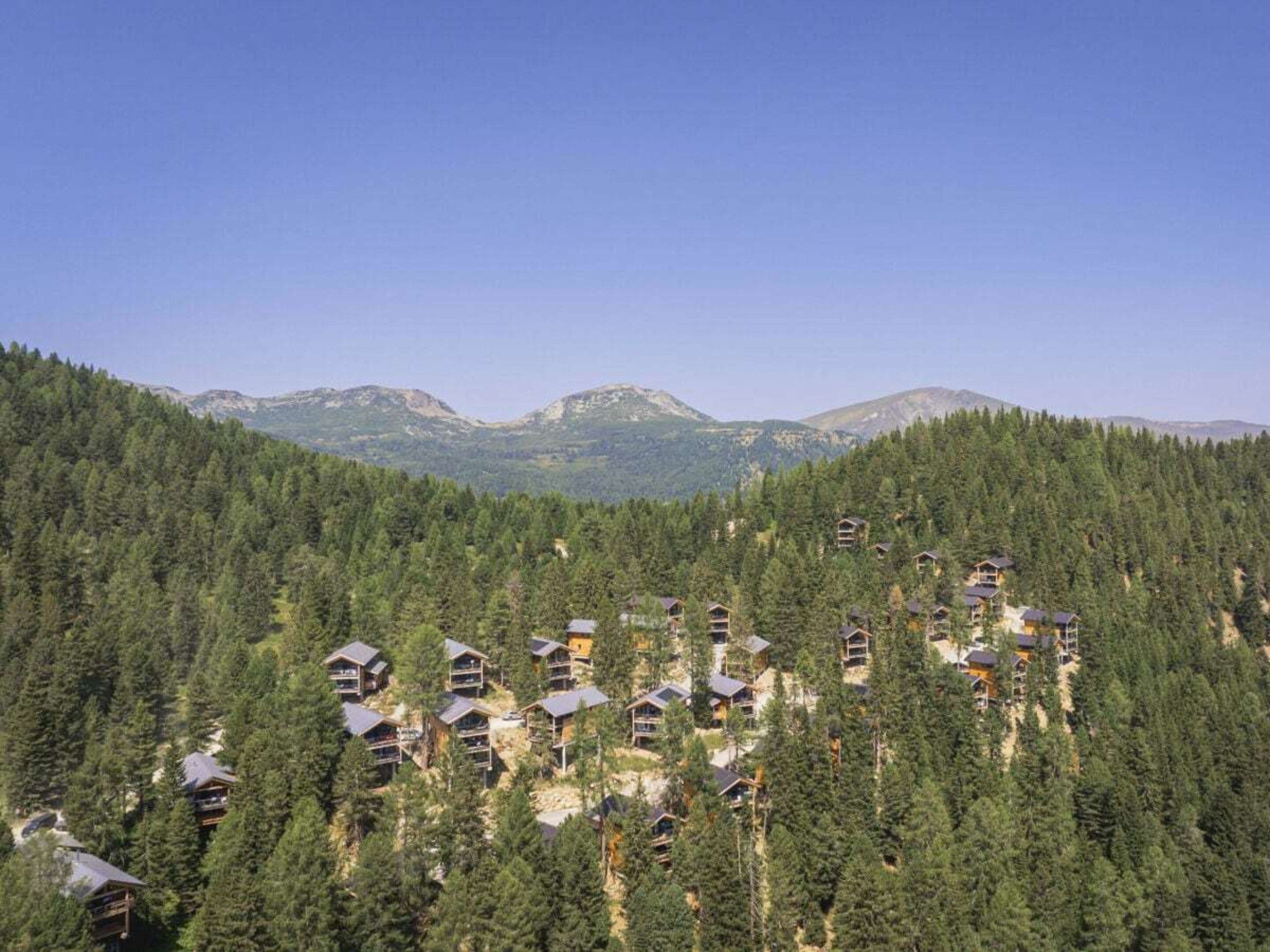 Une zone montagneuse boisée comprenant plusieurs chalets.