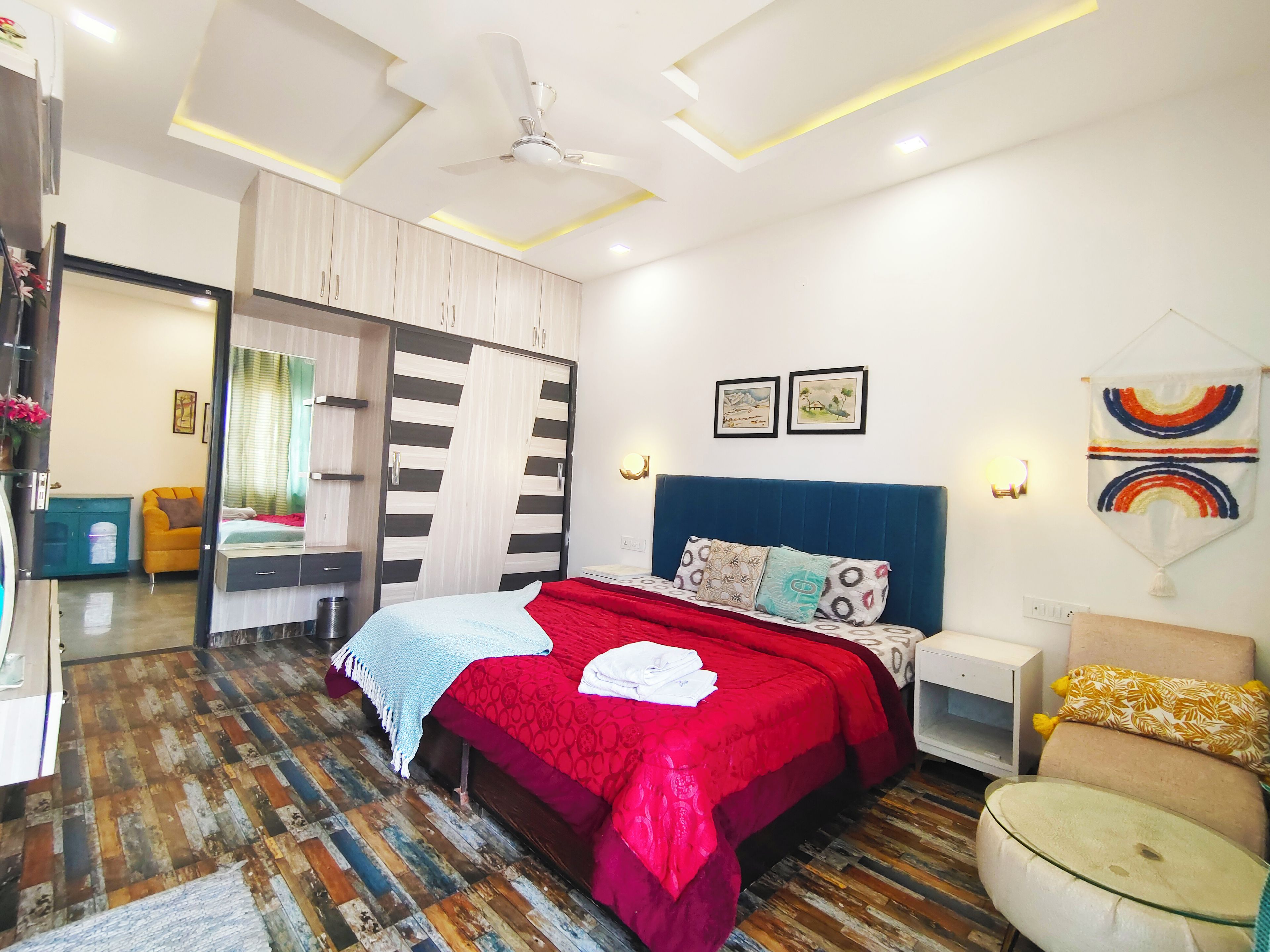 A modern bedroom with a bed, a wardrobe, a desk, and a chair.
