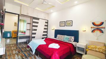 A modern bedroom with a bed, a wardrobe, a desk, and a chair.