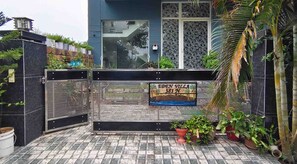 A gated entrance with a sign reading 'EDEN VILLA 581 NW' and a tiled patio area with potted plants. - Eden Villa (Kharar)